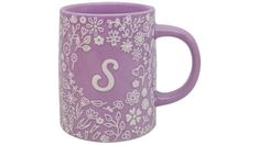 a purple mug with white flowers and the letter s on it