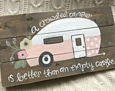 a wooden sign with a pink camper painted on it's front and back