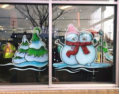 two frosty snowmen in front of a store window