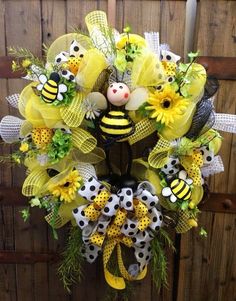 a yellow and black wreath with flowers, bees and polka dots on the front door