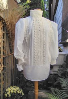 A truly beautiful replica of a Lady,s Heritage Shirt Waist [Blouse] and handmade in your exact measurements. Gently crafted in a cotton-poly batiste,with 100% Cotton Imported Cluny Lace,charming pin tucks and self covered fabric front buttons and full back button closure.Extra long for "tuckability"for the active woman. Custom sizing from S-2XL Paired with a long skirt to celebrate the beauty of eras past. Classic Tops With Bishop Sleeves For Daywear, Fitted Cotton Tops With Bishop Sleeves, Classic Bishop Sleeve Tops For Daywear, Fitted Cotton Top With Bishop Sleeves, Vintage White Bishop Sleeve Tops, White Bishop Sleeve Tops For Daywear, Cotton Bishop Sleeve Fitted Blouse, Fitted Cotton Blouse With Bishop Sleeves, Classic Fitted Blouse With Bishop Sleeves