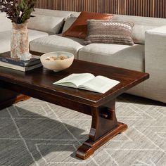 a coffee table with a bowl of cereal and a book on it in front of a couch