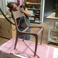 a man is working on a chair in a shop with pink towels and other tools