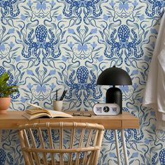 a table with a lamp and some books on it next to a wallpapered room