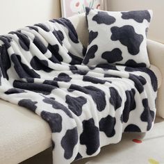 a cow print blanket sitting on top of a couch