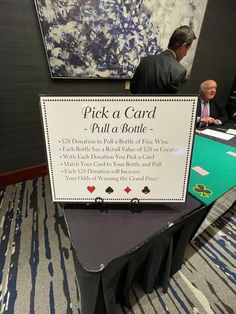 a table with a sign on it that says pick a card, pull a bottle