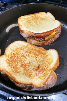 two toasted sandwiches sitting on top of a frying pan