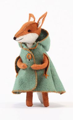 a stuffed animal in a green dress with an orange fox on it's back