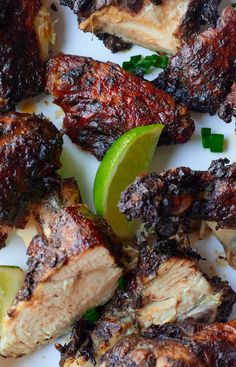 grilled chicken and limes on a white plate