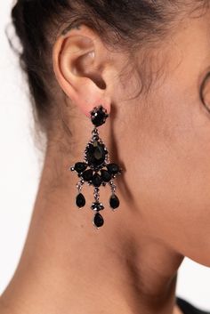 The earrings feature a teardrop-shaped rhinestone crystal at the top, with multiple smaller crystals hanging down in a chandelier style. The crystals are arranged in a beautiful pattern that creates a sparkling and elegant effect. The earrings are lightweight and comfortable to wear, making them perfect for special occasions. SizeLength: 2.75 in (6.99 cm)Width: 1.25 in (3.18 cm) QualityUses an eco-friendly, lightweight, strong metal alloy base structure. Adorned with dangling teardrop sparkling Teardrop Crystal Chandelier Earrings For Pierced Ears, Teardrop Crystal Chandelier Earrings, Jeweled Teardrop Crystal Chandelier Earrings, Crystals Hanging, Crystal Chandelier Earrings, Black Earrings Dangle, Pearl Shop, Holiday Essentials, Chandelier Style