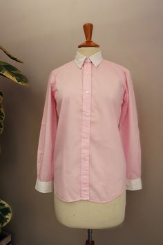 Lovely pastel pink button down shirt  with crisp white collar and the white cuffs. Tagged size Small Material : 65%polyester 45%cotton Measurements taken laying flat Bust (armpit to armpit) :48cm Waist:47cm Length from shoulder down:66cm Sleeve inseam:47cm Shoulders:40cm Condition:Very good,with a faded mark on the right sleeve not really noticeable when you wear it (see pics).May come out when washed. White Dress Shirt With Striped Collar For Work, Pink Button-up Dress Shirt, Pink Spread Collar Shirt For Office, Pink Collared Shirt For Daywear, Pink Button-up Formal Shirt, Pink Button-up Dress Shirt For Work, Pink Cotton Button-up Dress Shirt, Pink Collared Top With Striped Collar, Pink Spread Collar Dress Shirt For Work