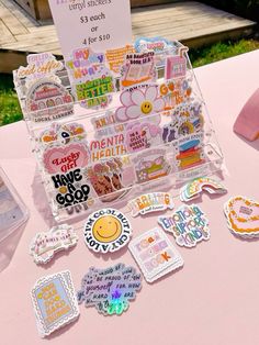 a table topped with lots of stickers on top of a pink cloth covered table