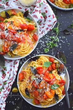 two bowls of pasta with tomato sauce and parmesan cheese