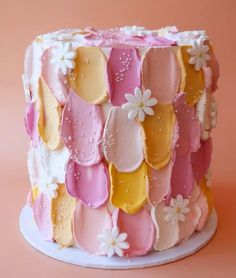 a colorful cake decorated with flowers and petals