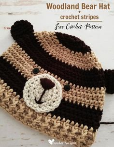 a crocheted hat with a teddy bear on the front and brown, white, and black stripes