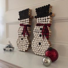 two snowmen made out of wine corks on a mantle