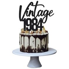 a black and white cake with the words vintage 1994 on it, sitting on a plate