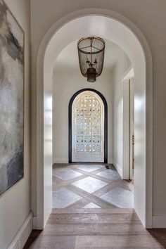 an archway leading to a large entryway with a black door and window in the center