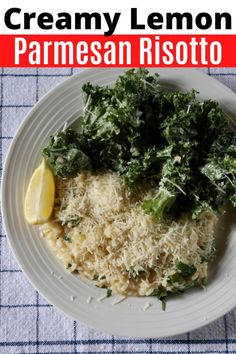 a white plate topped with parmesan risotto next to a lemon wedge