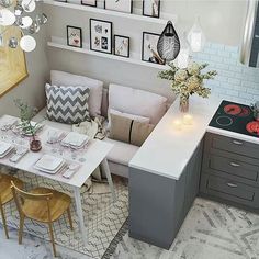 an aerial view of a kitchen and living room in one photo, with the dining table laid out on the other side