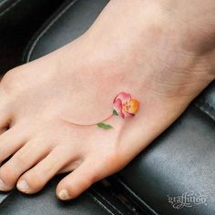 a small flower tattoo on the foot