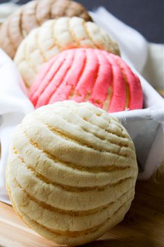 four different types of pastries in a white container on a table top with napkins