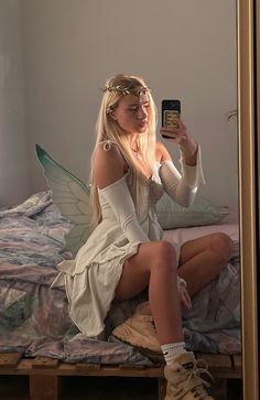 a woman sitting on a bed taking a selfie