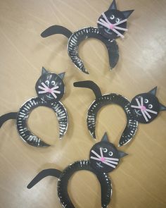 four black cat paper plates sitting on top of a wooden table