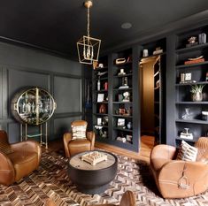 a living room filled with lots of furniture and bookshelves in front of black walls