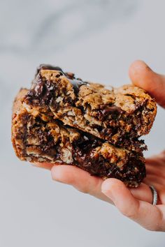 a person holding two cookies in their hands