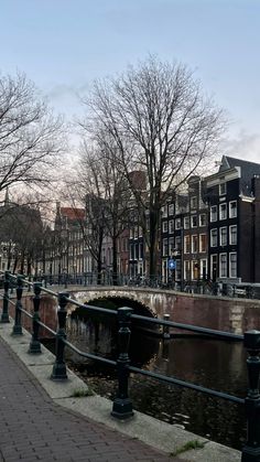 a bridge over a small river next to tall buildings