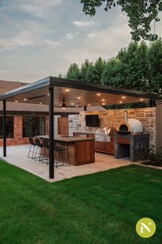 an outdoor kitchen and grill area in a backyard