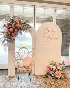 a chair sitting next to a sign that says baby in bloom