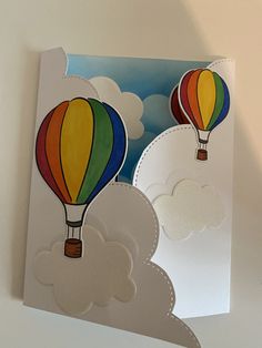 a card with two hot air balloons flying in the sky