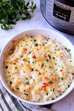 a casserole dish with cheese and parsley in front of an instant pressure cooker