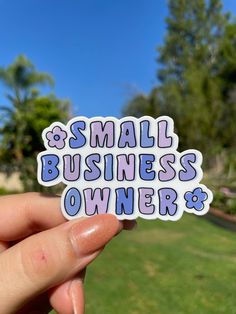 someone holding up a sticker that says small business owner