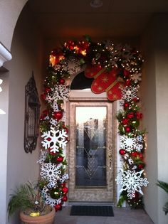 the front door is decorated for christmas with snowflakes and wreaths on it