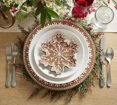 a table setting with silverware and red wine glasses