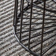 a close up view of the bottom of a metal chair with woven fabric on it