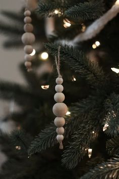 a close up of a christmas tree with ornaments hanging from it's branches and lights in the background