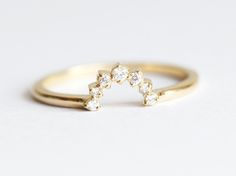 a gold ring with five diamonds on it