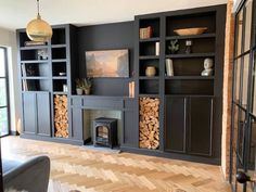 a living room filled with furniture and a fire place in the middle of a wooden floor