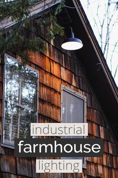 the words industrial farmhouse house lighting are in front of a brown wooden building with windows