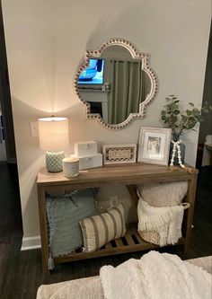 a wooden table topped with pillows and a mirror