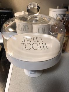 there is a glass container that has some toothpaste in it and the words sweet tooth on it