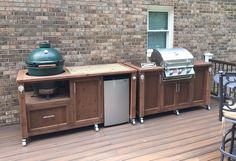 an outdoor kitchen with grill and cabinets on the deck