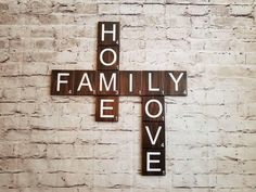 a cross made out of scrabble tiles with the words family love spelled on it