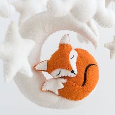 an ornament with a fox on it is hanging from the ceiling in front of white stars