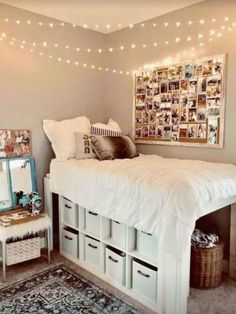 a white bed sitting in a bedroom next to a rug and lights on the wall