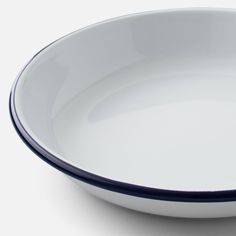 a white bowl with blue rim sitting on top of a table